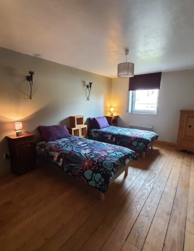 Une chambre avec deux lits et un parquet