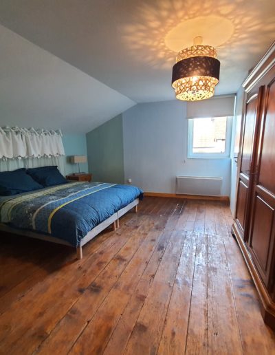 Une chambre avec un vieux parquet en bois massif